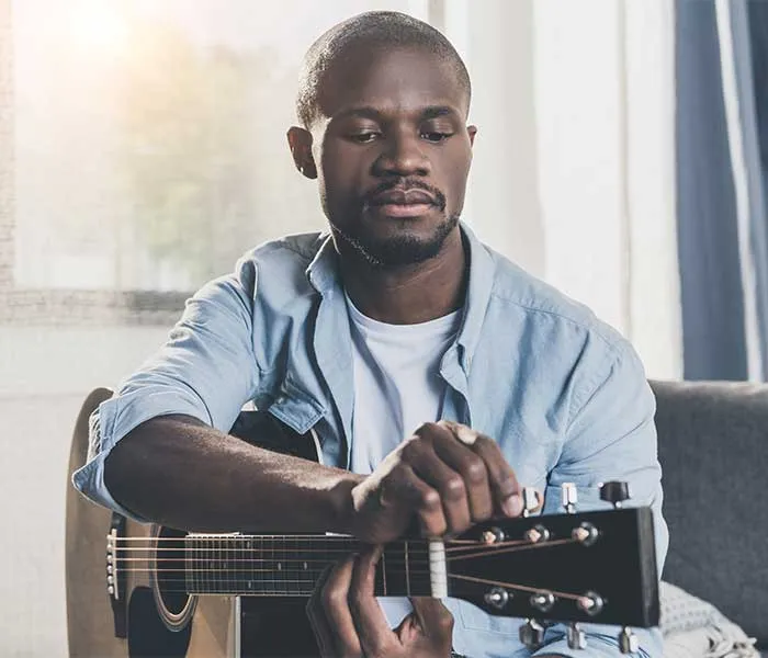 Man tuning a guitar